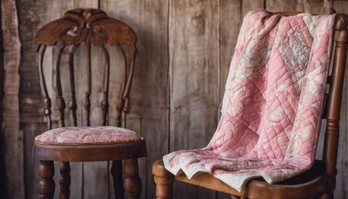 Trapunta vintage con motivo cachemire rosa, drappeggiata su un&#39;antica sedia in legno.