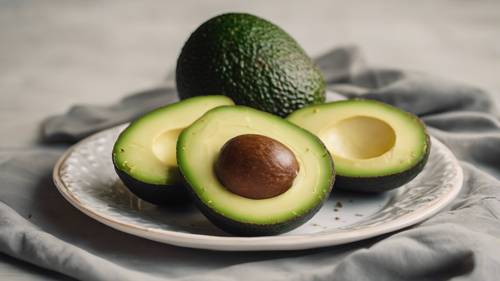 An avocado sliced into neat symmetrical pieces on a plate