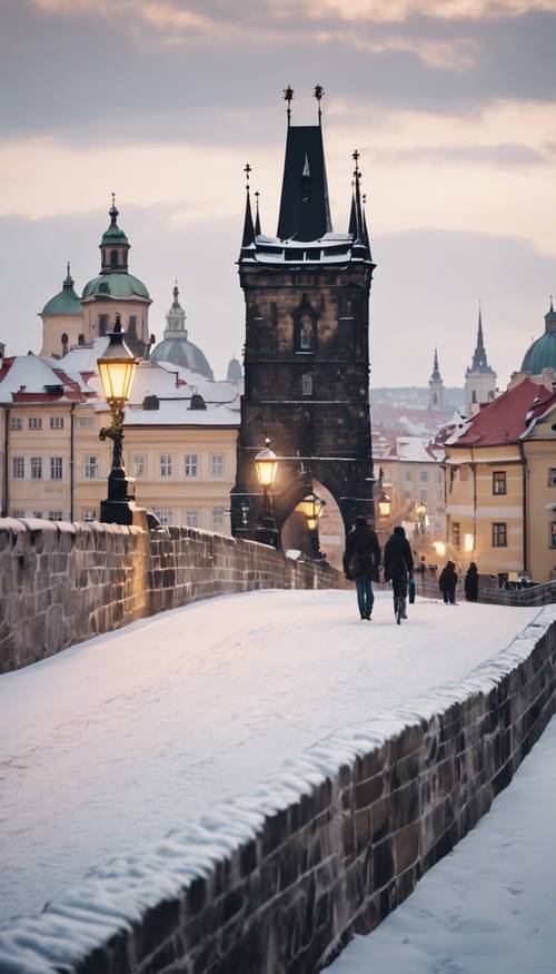 Widok na Most Karola w Pradze zimą, pokryty śniegiem.