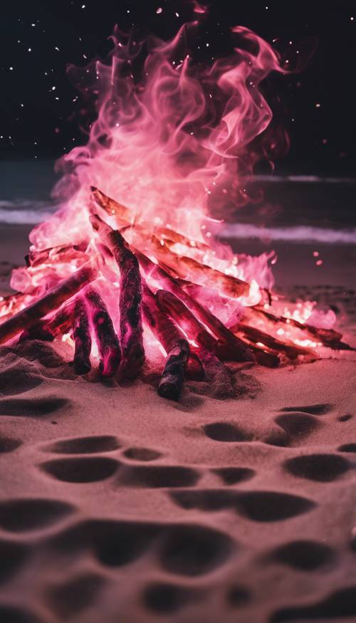 Api unggun besar berwarna merah muda di pantai sepi di malam hari.