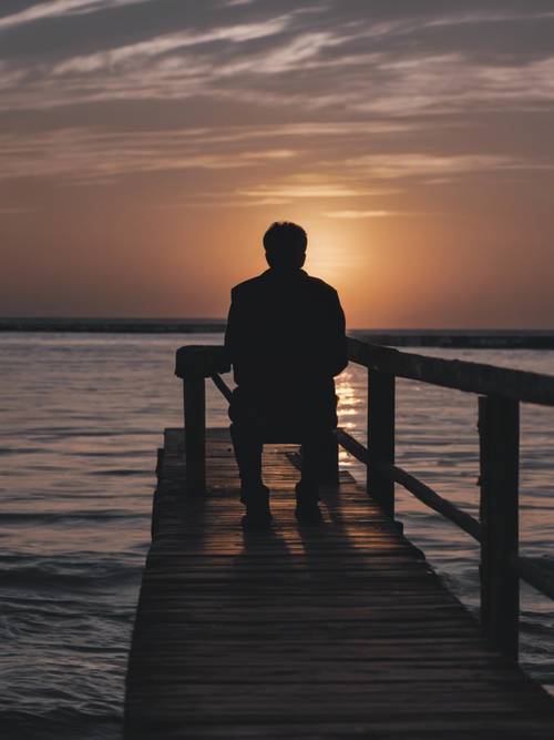 Dark silhouette of a lone figure sitting at the end of the pier looking into the sunset, carrying the caption 'Sometimes I just want to disappear'.