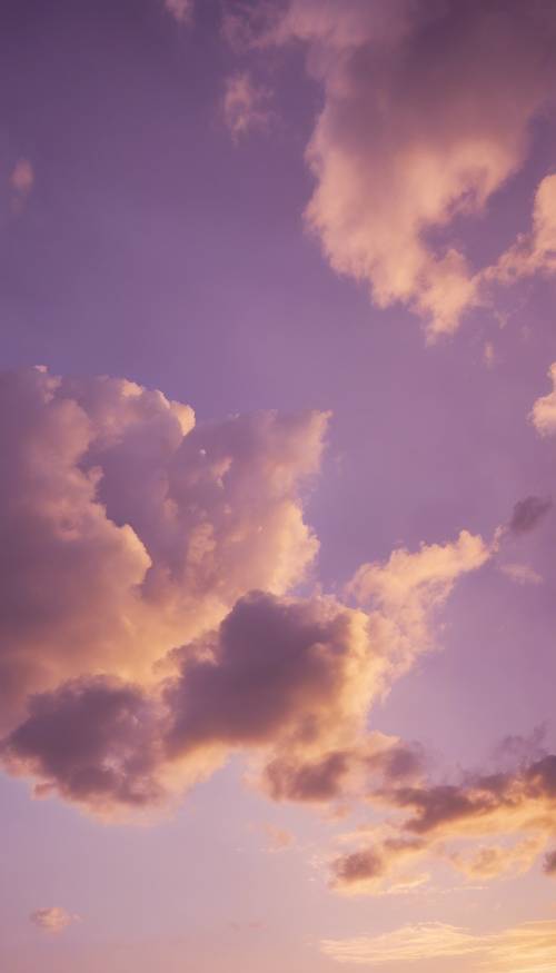 Eine goldene Sonne hängt tief in einem sanften, violetten Abendhimmel voller flauschiger Wolken.