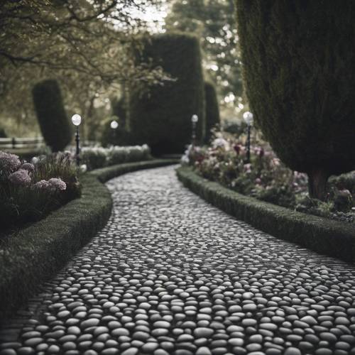 A heart-shaped cobbled path in shades of black and gray in an English garden.