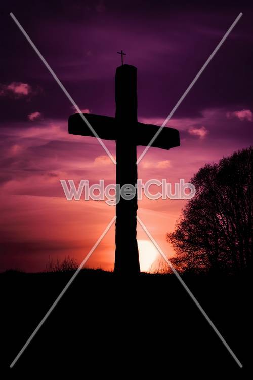 Silhouette al tramonto di una croce su una collina