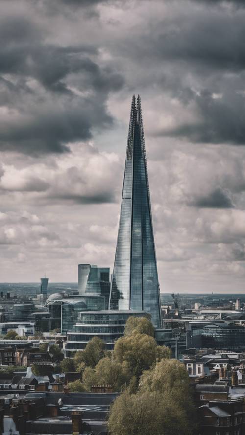 Wide view of London cityscape, including the Shard, under a cloudy sky.”