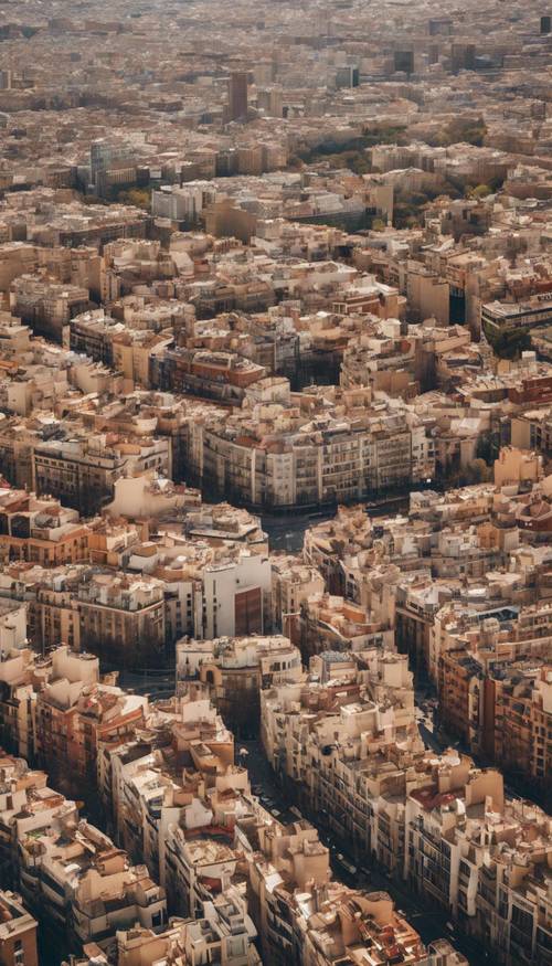 Una veduta aerea del paesaggio urbano di Barcellona sotto un cielo limpido e soleggiato, che mette in mostra la sua struttura a griglia meticolosamente pianificata.