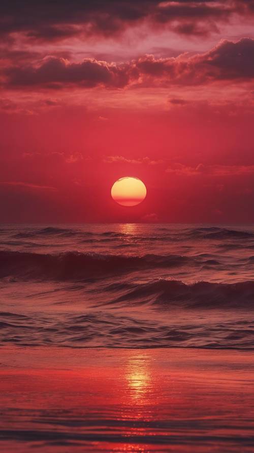 غروب الشمس القرمزي الأحمر الياقوتي، في سماء ذهبية فوق بحر هادئ.