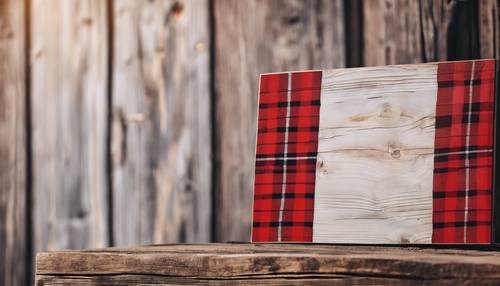 Targa rustica in legno con motivo scozzese rosso e bianco, appoggiata al muro del fienile.