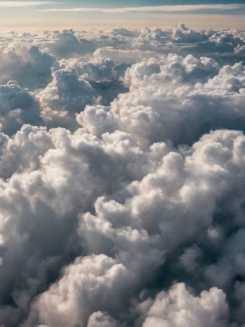 Foto udara awan tebal terlihat dari jendela pesawat.