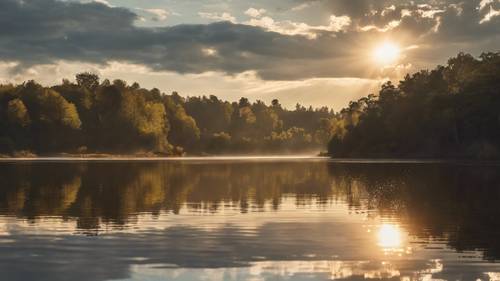 The morning sun reflecting on a tranquil lake has an iPhone 15 Pro sitting on the edge, capturing the breathtaking scenery. Tapéta [2c37537f87644d6b916f]