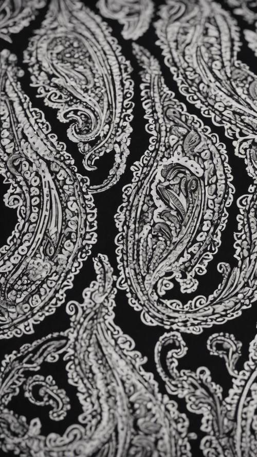 Detalhe em close de tecido macio de algodão com estampa paisley monocromática.
