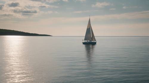 A tranquil scene of a sailboat journeying across the vast freshwater expanse of Lake Superior in Michigan's Upper Peninsula.