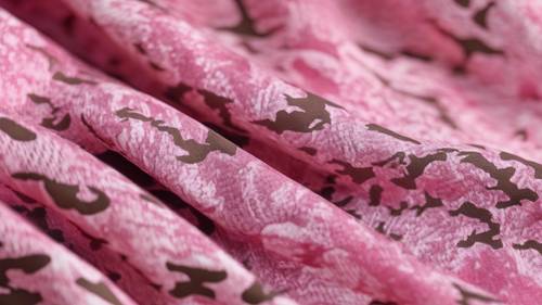 Close detalhado de um tecido texturizado com desenho de camuflagem rosa.