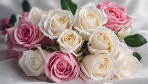 Ein lebendiger Strauß weißer und rosa Rosen, dicht gebunden und mit einem Satin-Seidenband zusammengebunden.