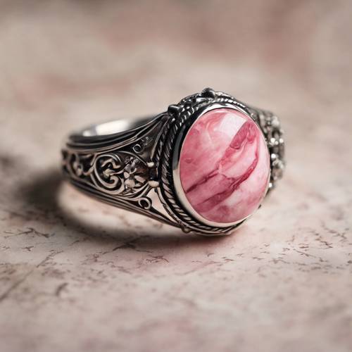 Custom cut pink marble gemstone in a vintage silver ring.