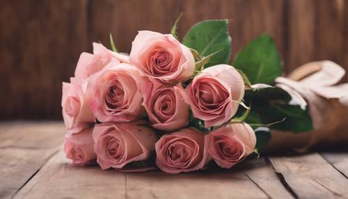 Ein Strauß rosa Rosen, eingewickelt in rustikales braunes Papier.