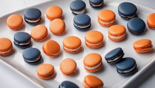 Marineblaue und orange Macarons ordentlich auf einem weißen Teller angeordnet.