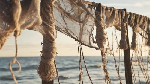 A row of rustic linen fishing nets hung out to dry along the ocean pier.