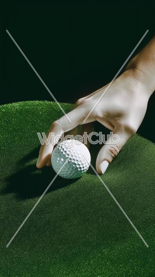在绿色表面上握住高尔夫球的手的特写镜头