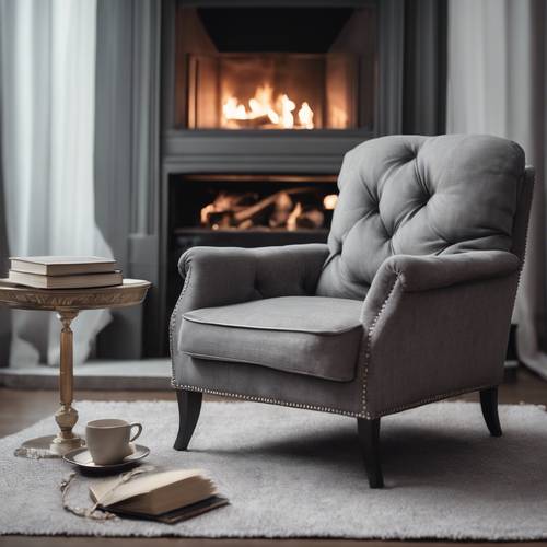 A luxurious gray linen armchair placed next to a fireplace, with a good book lying on it.