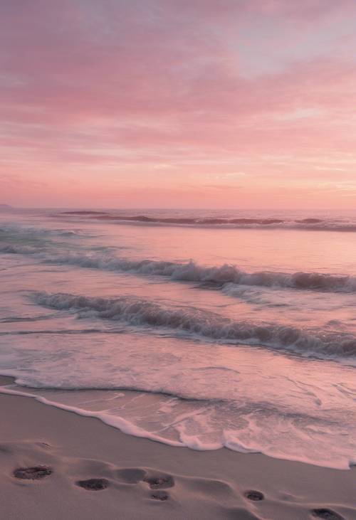 Una tranquila puesta de sol de color rosa pastel sobre el océano, con las olas golpeando suavemente la playa de arena.