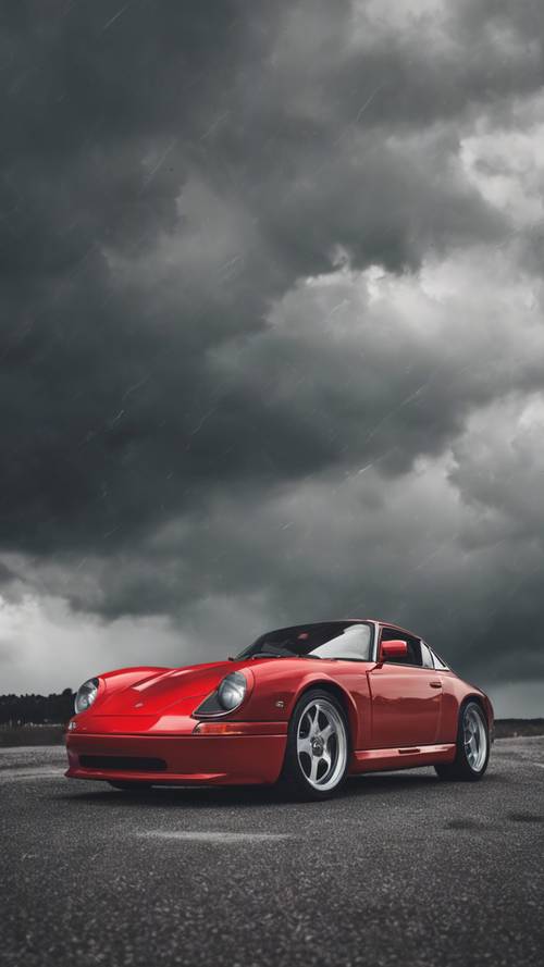 Gri, fırtınalı bir gökyüzünün altına park edilmiş ateşli kırmızı bir spor araba.