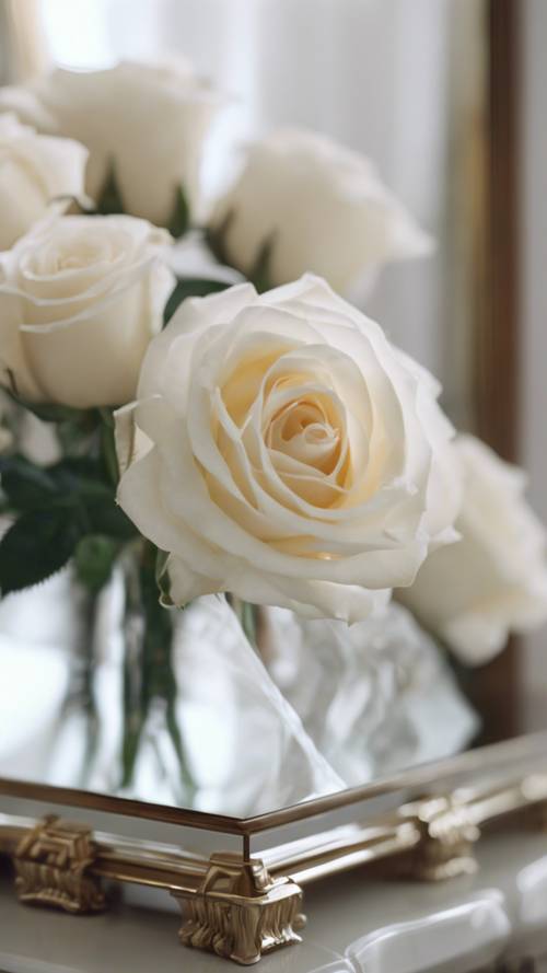 Weiße Rosen lugen aus ihrem Spiegelbild auf einem Frisiertisch hervor.