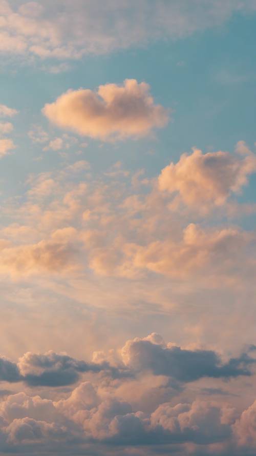 Um céu azul pastel ao nascer do sol com algumas nuvens solitárias.