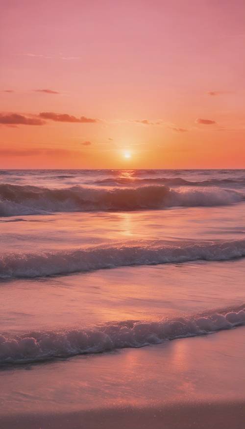 غروب الشمس على الشاطئ الهادئ يعرض المحيط الذي يعكس السماء باللون الوردي الفاتح المذهل إلى اللون البرتقالي.