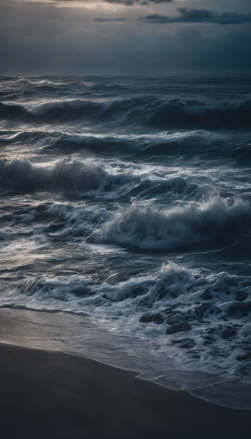 A serene dark blue ocean with crashing waves on a cloudy night.