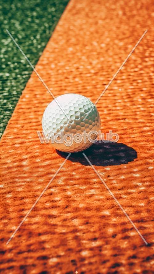 オレンジ色のテクスチャー背景にあるゴルフボール