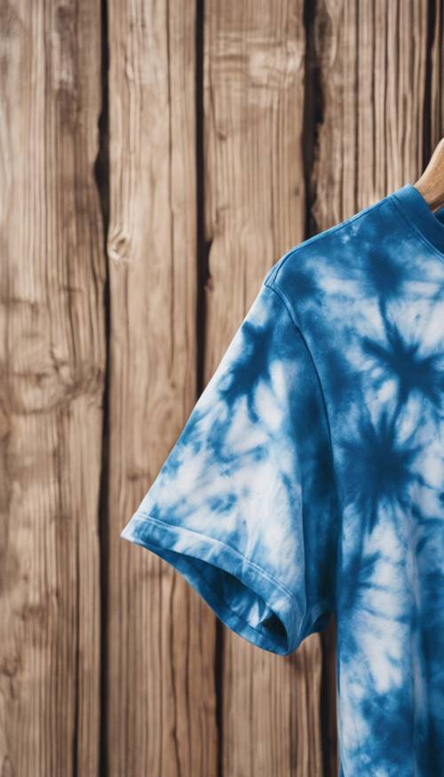 צילום תקריב של חולצת טריקו בצבע כחול על רקע עץ.