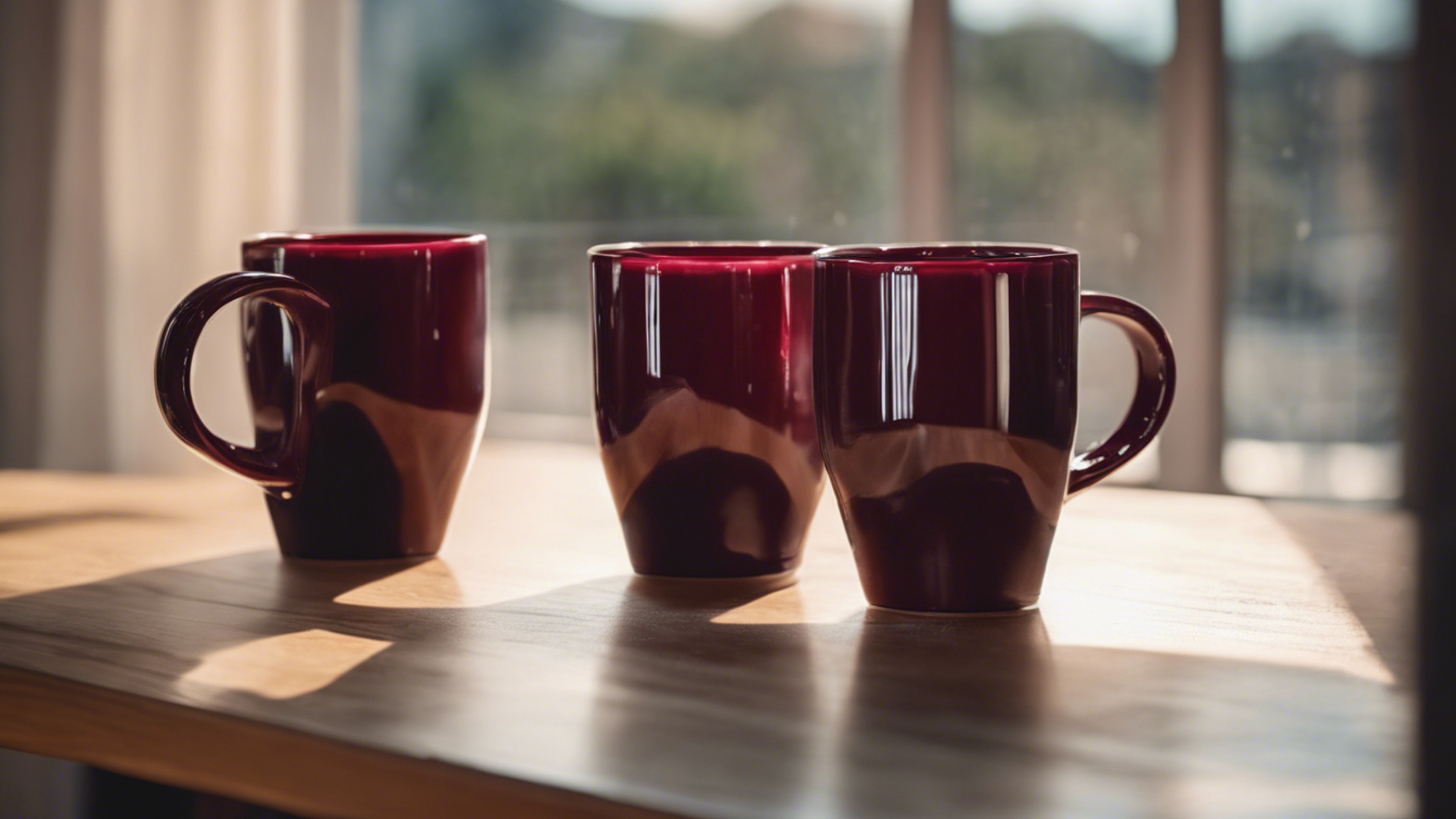 Two cool maroon ceramic coffee mugs set on a wooden table in front of a sunny window. Wallpaper[32923f9dbf0d44d9b281]