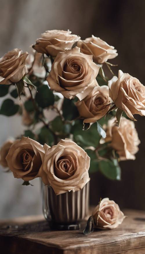 Un ramo de rosas otoñales de color beige oscuro en un jarrón rústico sentado sobre una mesa de café de madera.