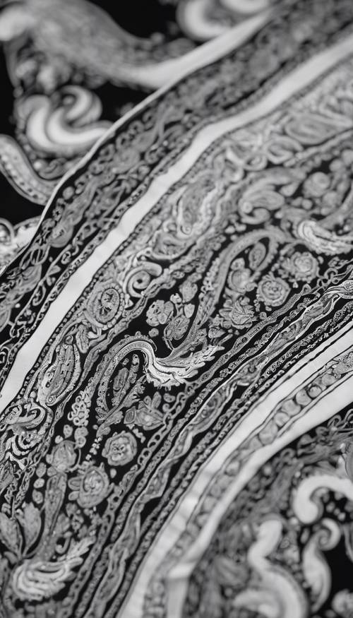 Um close detalhado de um padrão Paisley preto e branco em um lenço de seda.