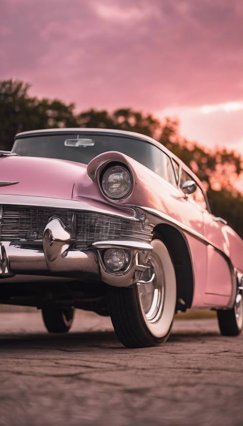 Ослепительно-серебристый классический автомобиль 1950-х годов, сверкающий под розовым закатом.