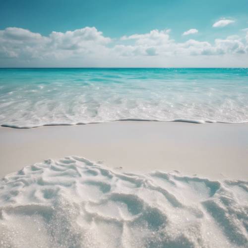 Una spiaggia di sabbia bianca, con tanto di cielo azzurro e acque turchesi.