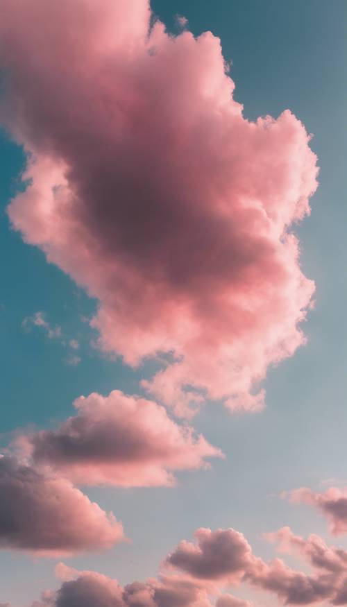 Тонкое облако с постепенным переходом от розового до голубого цвета на фоне ясного неба.
