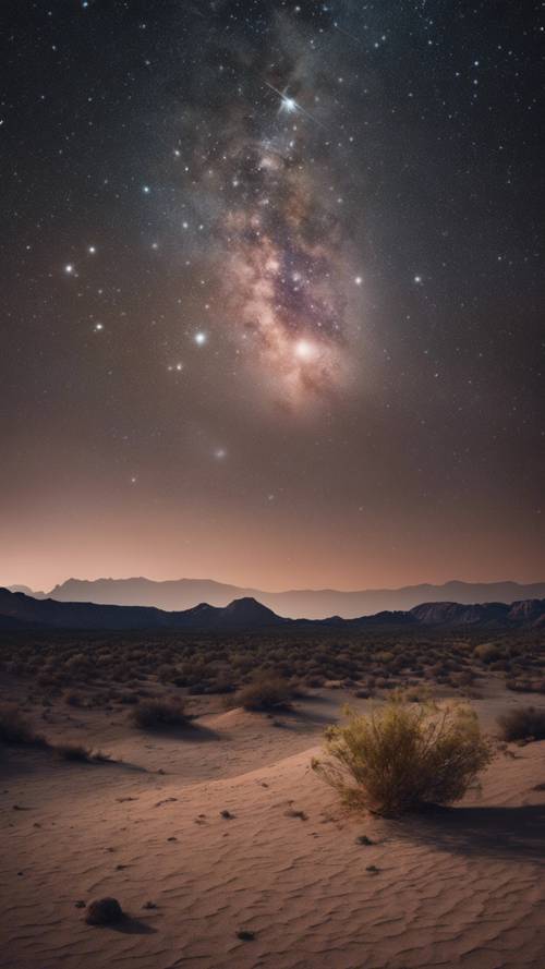 Konstelacja Pasa Oriona widziana nocą z pustynnego krajobrazu.