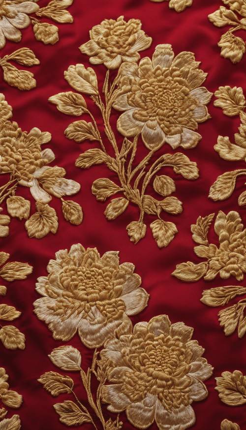 A intricate embroidery of gold-threaded chrysanthemums on a rich red Chinese silk.