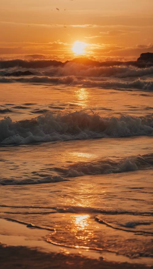 Żywy zachód słońca nad plażą, ukazujący odcienie jasnożółtego i głębokiego pomarańczu.