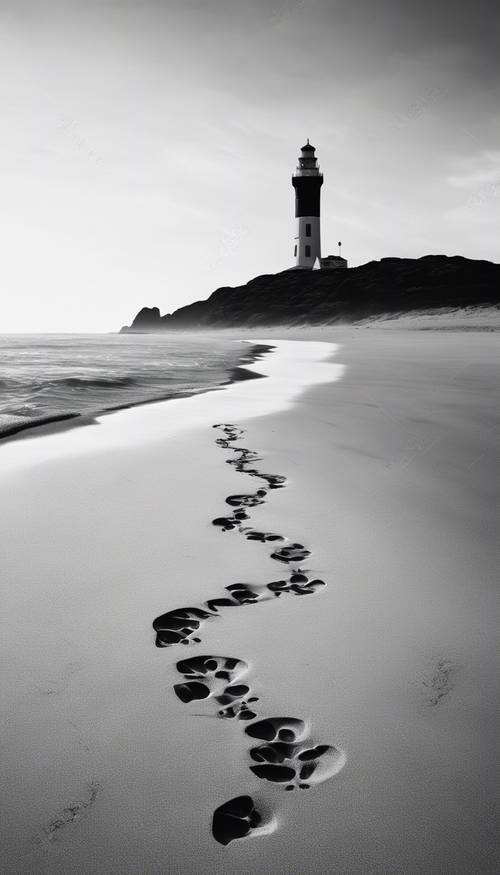 这是一张高对比度的黑白海滩图像，上面的脚印指向远处的灯塔。