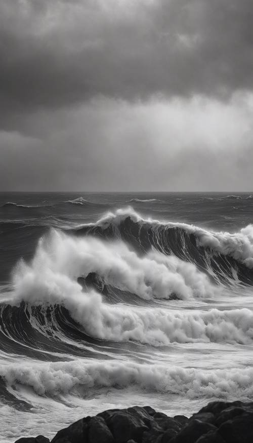 Gambar skala abu-abu dari samudra yang dalam dan menakutkan saat terjadi badai, ombak raksasa menghantam pantai yang tak terlihat.