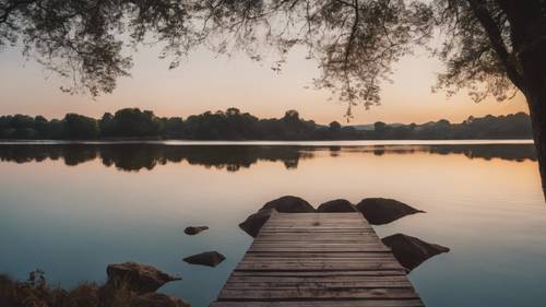 Une scène tranquille au bord d&#39;un lac au crépuscule, les eaux silencieuses reflétant la phrase « Votre temps est limité, ne le gaspillez pas à vivre la vie de quelqu&#39;un d&#39;autre. »