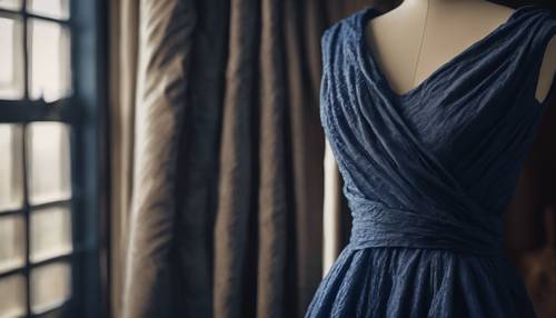 Granatowa sukienka teksturowana, pięknie udrapowana na manekinie.