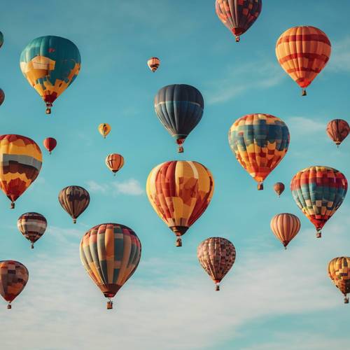 Różnorodne tętniące życiem balony na ogrzane powietrze wznoszące się w bezchmurne, błękitne niebo