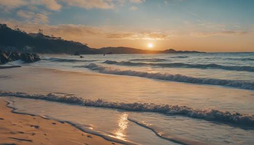 La impresionante imagen de una playa durante el amanecer, sus tonos dorados contrastan con el calmante azul del océano.