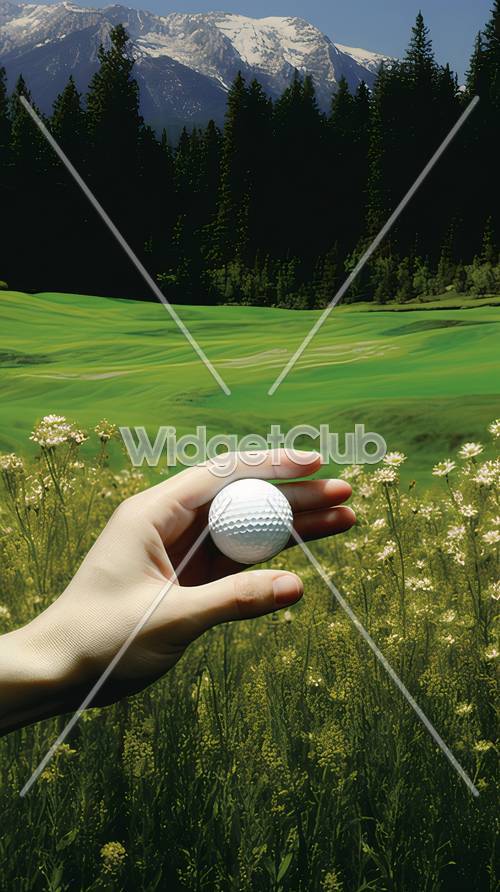 Pelota de golf en mano con exuberante campo verde y flores