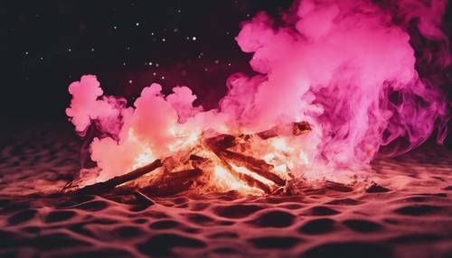 Una intensa llama de humo rosa de una hoguera nocturna en la playa.
