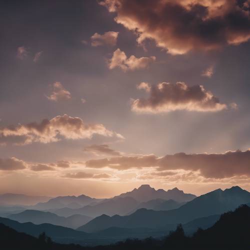 Un paysage abstrait au crépuscule, avec de grands nuages ​​spectaculaires et des montagnes en silhouette.